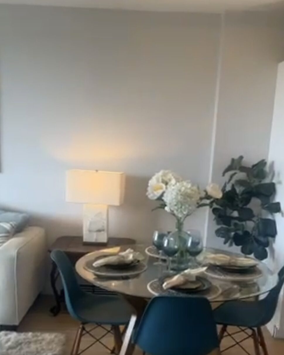 Clean dining area with a glass table and blue chairs